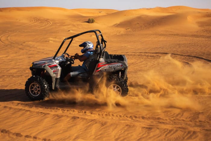 jeune homme qui fait du buggy dans le desert
