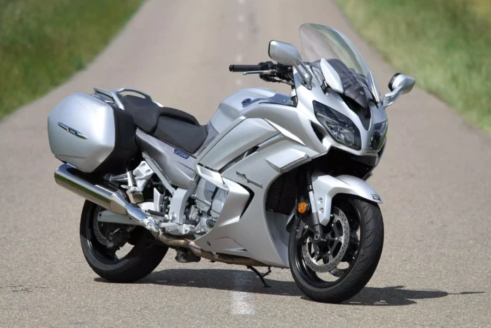 Moto routière Yamaha FJR gris métallisé garée sur une route de campagne